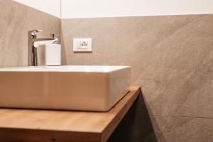 a bathroom with a white sink on a wooden counter at Apartment Toni - Obermösslhof in Lana