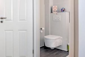 a bathroom with a toilet and a white door at Wohnen im Heidehaus in Sankt Dionys +12 photos