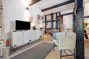 a living room with a tv and a couch and a tv stand at Wohnen im Heidehaus in Sankt Dionys