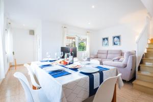 a white dining room with a table and chairs at Casa Mar in Vinarós