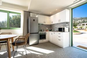 a kitchen with white appliances and a table with chairs at Joy Aqua in Skala +13 photos