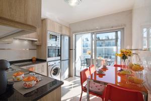 a kitchen with a table with red chairs and a dining room at Numar Residence Villa X in Manta Rota