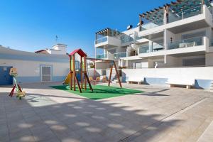 a playground in front of a apartment building at Numar Residence Villa X in Manta Rota