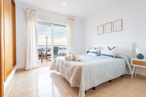 a white bedroom with a bed and a balcony at Casa Mar in Vinarós +22 photos