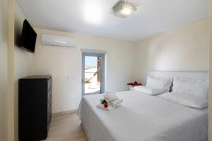 a bedroom with a large white bed with a television at Numar Residence Villa X in Manta Rota +22 photos