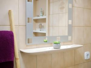 a bathroom with a sink and a mirror and purple towels at Ferienwohnung mit Garten in Ehrenkirchen +18 photos