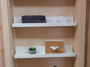 a shelf in a bathroom with towels and a wooden box at Ferienwohnung mit Garten in Ehrenkirchen