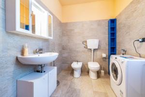 a bathroom with a sink and a washing machine at Casa Caterina con giardino in Marone +15 photos