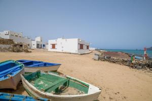 two boats sitting on a beach with buildings at Loft La Caletilla La Graciosa in Caleta de Sebo