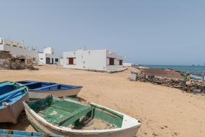 two boats sitting on a beach with buildings at Loft La Caletilla La Graciosa in Caleta de Sebo