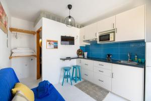 a kitchen with white cabinets and blue tiles at Loft La Caletilla La Graciosa in Caleta de Sebo