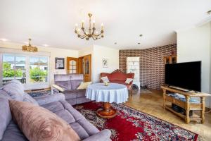 a living room with a couch and a tv at Ferienhaus Erlengrund A in Schafstedt