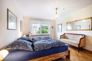 a bedroom with a bed and a couch and a window at Ferienhaus Erlengrund A in Schafstedt