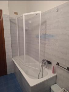 a bath tub with a shower in a bathroom at Il SORRISO in Moie