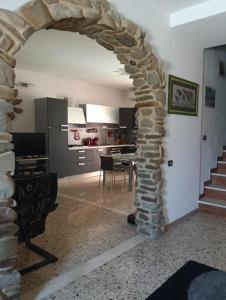 a living room with a stone archway and a kitchen at Il SORRISO in Moie