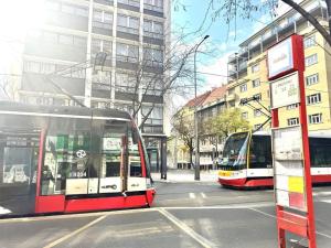 two buses are parked on a city street at Rabie Aparthotel in Prague