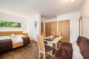 a bedroom with a bed and a table and a couch at Schnitzer Ferienwohnung Holunder in Rablà