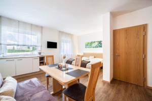 a kitchen and living room with a table and a couch at Schnitzer Ferienwohnung Holunder in Rablà