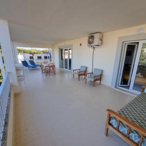 a large porch with chairs and tables and a television at Apartamento Portosun Pez in Portocolom