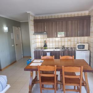 a kitchen with a wooden dining table and chairs at Apartamento Portosun Pez in Portocolom +5 photos