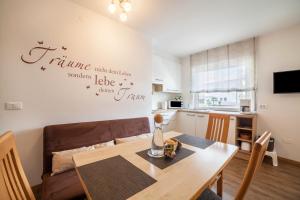 a dining room with a table and a kitchen at Schnitzer Ferienwohnung Holunder in Rablà