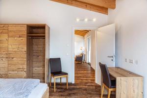 a bedroom with a bed and a desk and chairs at Ferienwohnung Wetterstein in Ehrwald