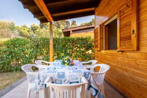 a table with white chairs sitting on a patio at Agriturismo Alimini a Otranto in Alimini