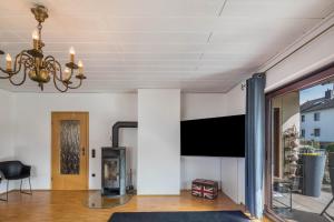 a living room with a tv and a chandelier at Am Twistesee 2 Ebenerdig in Wetterburg