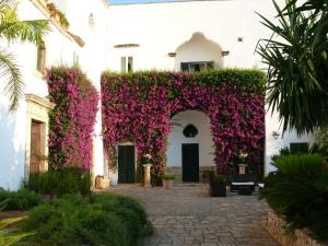 a white building with purple flowers on it at Villa Riggia in Nardò