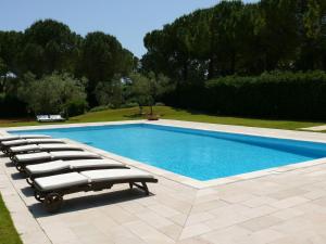 a swimming pool with lounge chairs next to it at Villa Riggia in Nardò