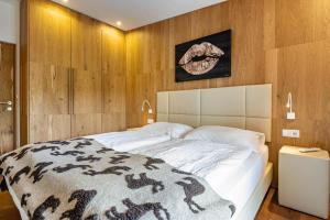 a bedroom with a large white bed with wooden walls at Chalet Hubertus in Kastelruth