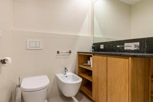 a white bathroom with a toilet and a sink at Chalet Hubertus in Kastelruth +22 photos