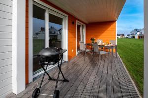 a bbq grill on a porch with a table at Fewo Meerwert by Seeblick Ferien in Kappeln