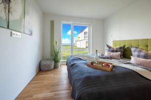 a bedroom with a bed with a tray of fruit on it at Fewo Meerwert by Seeblick Ferien in Kappeln