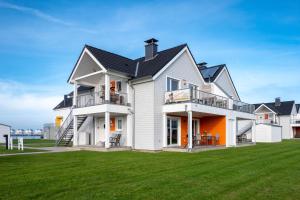 a large white house with a black roof at Fewo Meerwert by Seeblick Ferien in Kappeln