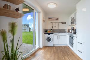 a kitchen with a washing machine and a large window at Fewo Meerwert by Seeblick Ferien in Kappeln