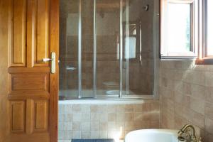 a shower with a glass door in a bathroom at Paz y Tranquilidad in Melarde +24 photos
