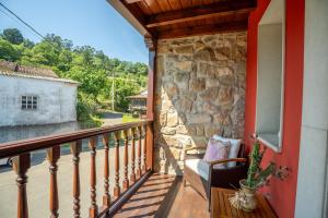 a balcony of a house with a stone wall at Paz y Tranquilidad in Melarde