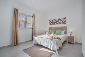 a bedroom with a bed with green pillows and a window at Casa Gara Fuerteventura in Gran Tarajal +26 photos