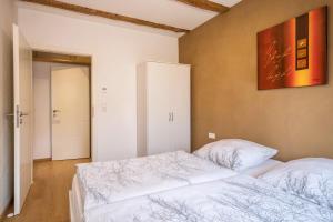 a bedroom with two beds and a painting on the wall at Ferienwohnung Lang in Kressbronn am Bodensee