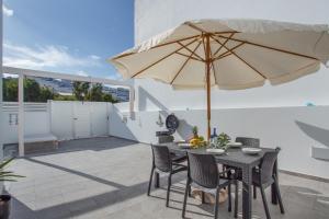 a table and chairs with an umbrella on a patio at Casa Gara Fuerteventura in Gran Tarajal