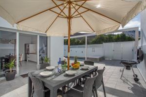 a table and chairs with a large umbrella on a patio at Casa Gara Fuerteventura in Gran Tarajal