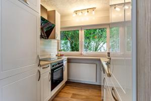 a kitchen with a stove and a sink and a window at Ferienwohnung Elim in Olsberg