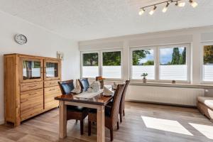 a dining room with a table and chairs and windows at Ferienwohnung Elim in Olsberg