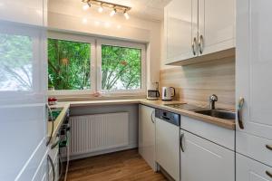 a kitchen with white cabinets and a sink and a window at Ferienwohnung Elim in Olsberg +15 photos