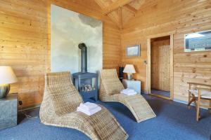 ein Zimmer mit zwei Korbsesseln und einem Ofen in der Unterkunft Witthus in Pellworm