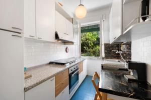 a kitchen with white cabinets and a blue stove top oven at Apartment Beach next to 5 Terre in Bonassola