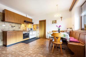 a kitchen with a table and a dining room at Ferienwohnung Gatscherhof in Luson