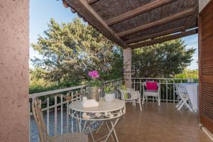 a patio with a table and chairs on a balcony at Villa Rosa sul mare in Olbia