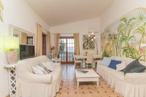 a living room with two white couches and a table at Villa Rosa sul mare in Olbia
